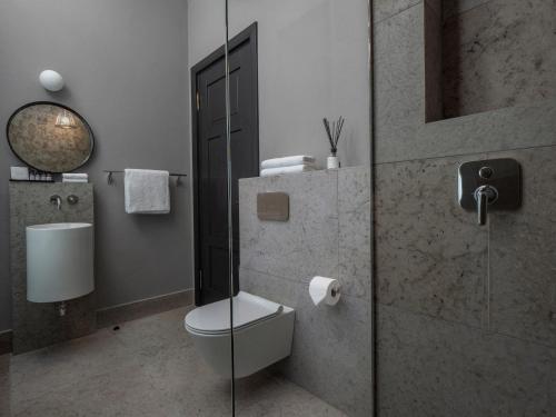 a bathroom with a toilet and a glass shower at Boutique Hotel Rosenplänter in Pärnu