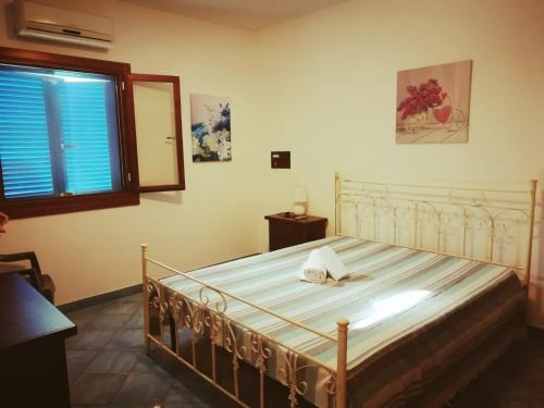 um quarto com uma cama com uma moldura branca e uma janela em Villetta Residence Chiusurelle em Porto Cesareo