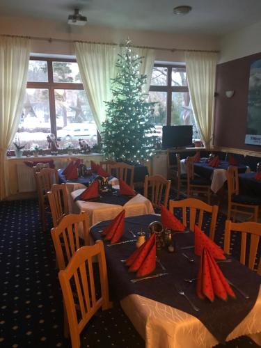 Un comedor con dos mesas y un árbol de navidad. en Penzión Slalom, en Tatranská Lomnica
