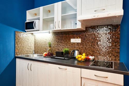 a kitchen with white cabinets and a counter with fruit on it at Residence Vaclavska in Prague