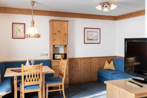 a living room with a table and a couch at Hotel Alpenrose in Pertisau