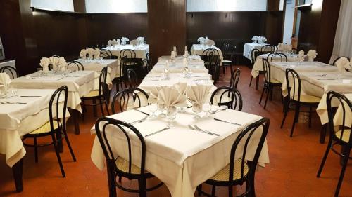 a group of tables with white table cloths on them at Hotel Galassia in Prato Nevoso
