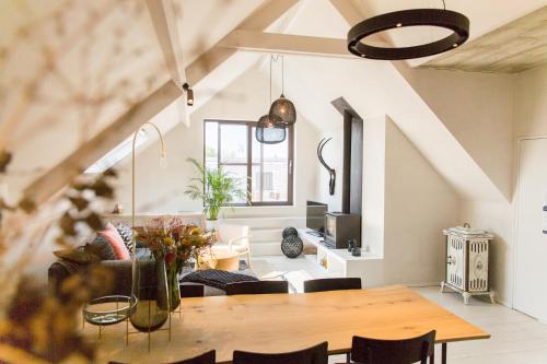 a dining room and living room with a wooden table at The Hide in Ghent