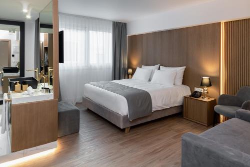 アテネにあるElia Ermou Athens Hotelのベッドとバスルームがあるホテルの部屋