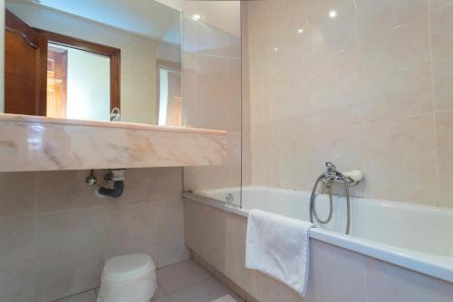 een badkamer met een bad en een wastafel bij Posada de la Abadia - Adults Only in Santillana del Mar