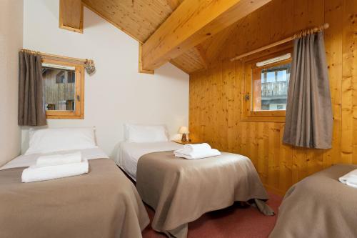A bed or beds in a room at Madame Vacances Les Chalets du Praz