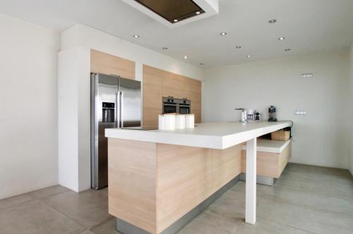 a kitchen with a white counter and a refrigerator at Villa Wivine in Moraira