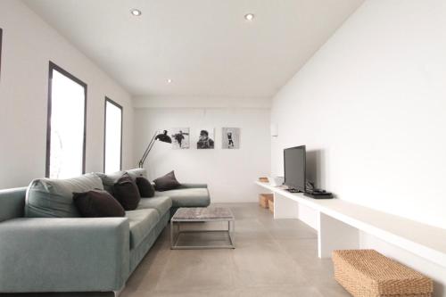 a living room with a couch and a tv at Villa Wivine in Moraira