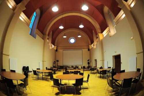 a large room with tables and chairs and a whiteboard at Le Prieuré in Saint-Dalmas-de-Tende