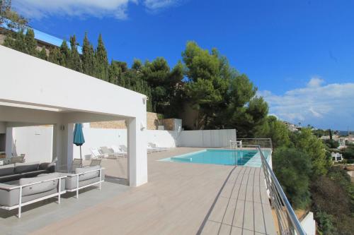 a house with a swimming pool and a wooden deck at Villa Wivine in Moraira