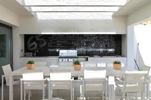 a dining room with a table and chairs and a chalkboard at Villa Wivine in Moraira