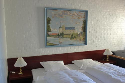 una pintura cuelga sobre dos camas en un dormitorio en Sølyst Kro- Restaurant og Hotel I/S en Åbenrå