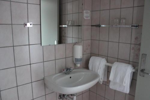 a bathroom with a sink and a mirror and towels at Sølyst Kro- Restaurant og Hotel I/S in Aabenraa