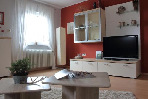 ein Wohnzimmer mit einem TV und einem Tisch in der Unterkunft Haus Kolmesfeld in Sensweiler