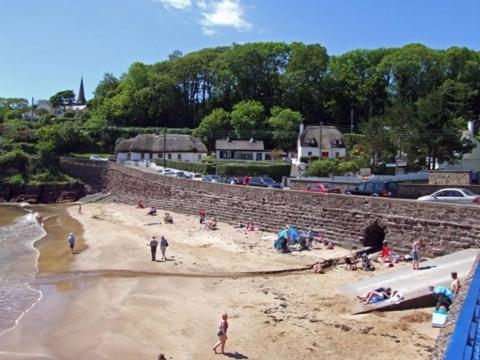 a group of people on a beach near the water at The Strand Inn in Dunmore East