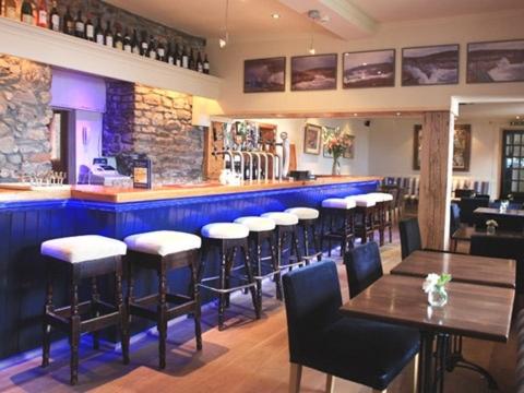 a bar with chairs and tables in a restaurant at The Strand Inn in Dunmore East