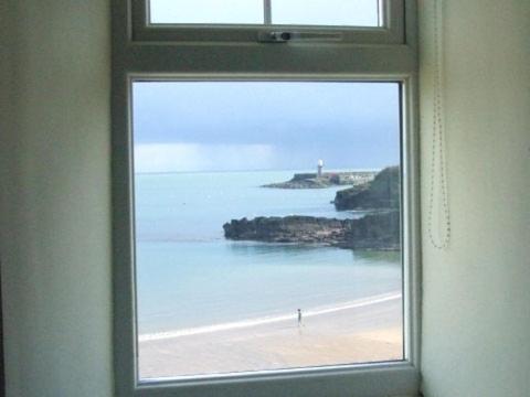 a window with a view of a beach and the ocean at The Strand Inn in Dunmore East