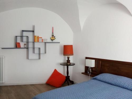 ein Schlafzimmer mit einem blauen Bett und einem roten Kissen in der Unterkunft la casa in collina in Vicoforte