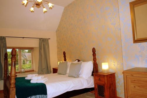 a bedroom with a bed with white pillows at Hillocks Cottage, Kniveton in Kniveton