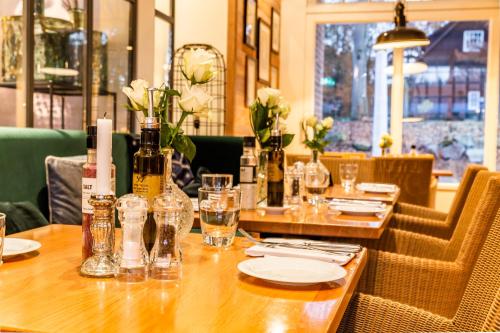 a table in a restaurant with bottles and glasses at Gut Altona in Dötlingen