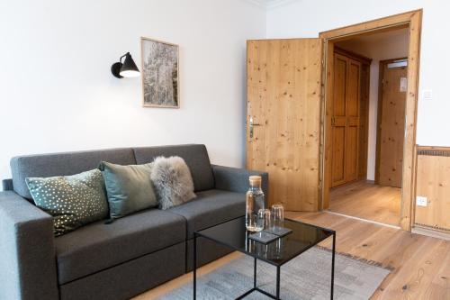 a living room with a couch and a table at Designhotel Sonnhof by Vitus Winkler in Sankt Veit im Pongau