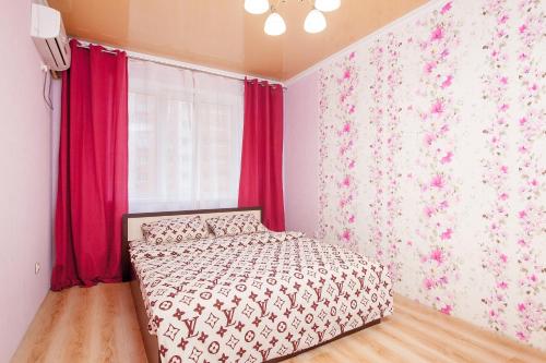 Schlafzimmer mit einem Bett und einem Fenster mit roten Vorhängen in der Unterkunft Panorama 22/2 in Krasnodar