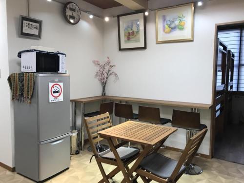 eine Küche mit einem Tisch, Stühlen und einer Mikrowelle in der Unterkunft Nono teru Narita in Narita