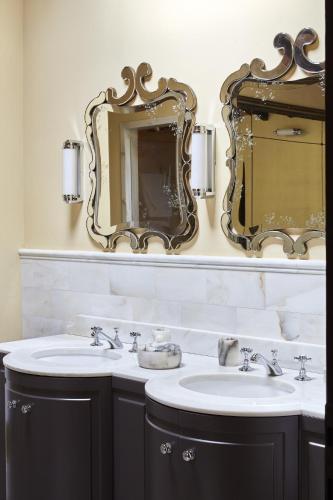 a bathroom with two sinks and a mirror at Castello di Casole, A Belmond Hotel, Tuscany in Casole dʼElsa