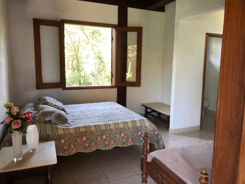 1 Schlafzimmer mit 2 Betten und einem Fenster in der Unterkunft Sitio das Posses - Zona Rural in Serra Azul