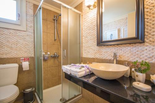 a bathroom with a sink and a shower and a toilet at Symi Nautilus Luxury Suites in Symi