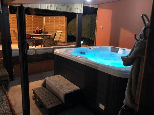 a large bath tub in a room with a patio at La chambre des Onglous in Marseillan