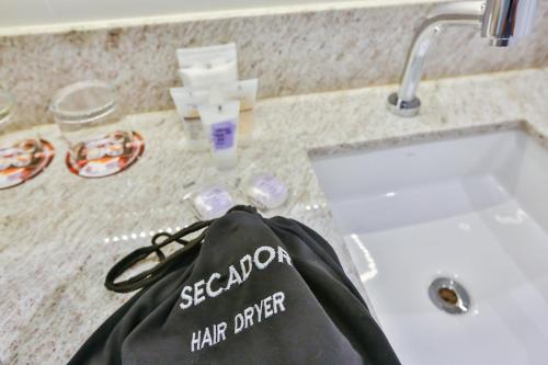 a black bag sitting on a counter next to a sink at Transamerica Collection Goiania in Goiânia