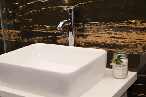 a white sink in a bathroom with a faucet at SohoSuites Villavieja in Alicante