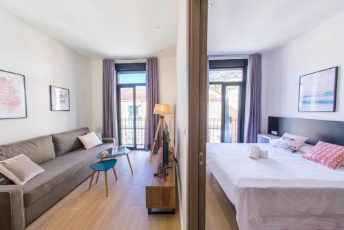 a bedroom with a large bed and a couch at SohoSuites Villavieja in Alicante