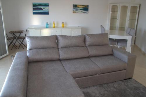 a brown couch in a living room with a table at Ericeira Sunset Apartment in Ericeira