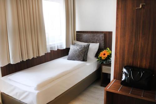 a small bed in a room with a window at Anor Hotel & Conference Center Frankfurt Airport in Mörfelden-Walldorf