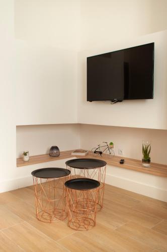 a living room with two tables and a flat screen tv at SohoSuites Villavieja in Alicante