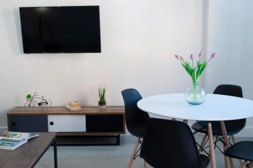 a meeting room with a table and chairs and a tv at SohoSuites Villavieja in Alicante
