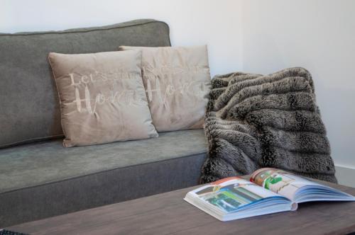 a book on a coffee table next to a couch at SohoSuites Villavieja in Alicante