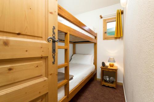 Habitación pequeña con litera y puerta en Madame Vacances les Chalets des Alpages, en La Plagne