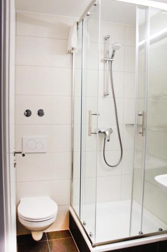 a bathroom with a shower with a toilet and a sink at Anor Hotel & Conference Center Frankfurt Airport in Mörfelden-Walldorf
