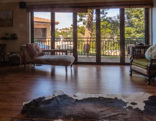 a living room with a view of a balcony at Ekhaya Guest House in Ballito