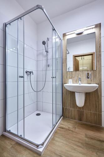 a bathroom with a glass shower and a sink at Penzion U Zámku in OÅ™echov