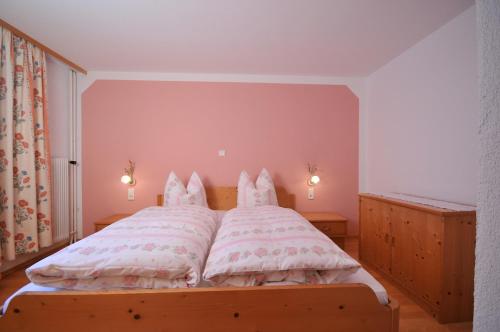 a bedroom with a large bed with white pillows at Hotel-Pension Faneskla in Silbertal