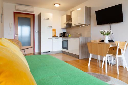 uma cozinha e uma sala de estar com uma mesa e uma televisão em A Twist of Lime em Moravske-Toplice