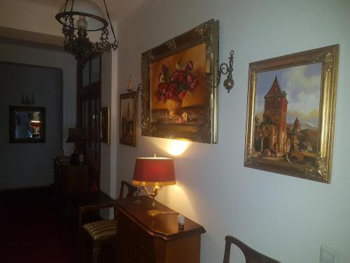 a room with a lamp and paintings on the wall at Willa Marysin in Maków Podhalański