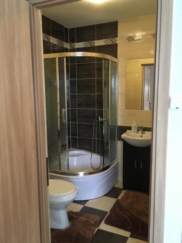 a bathroom with a tub and a toilet and a sink at Willa Diana- z panoramą jeziora i gór w Polańczyku in Polańczyk
