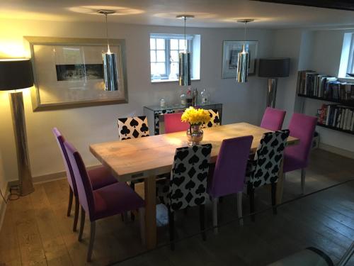 ein Esszimmer mit einem Holztisch und lila Stühlen in der Unterkunft Castle Mill Bed and Breakfast in Dorking