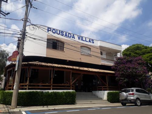 un bâtiment avec un panneau indiquant les villas pussada dans l'établissement Pousada Villas, à Sorocaba