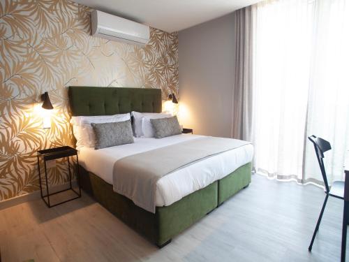 a bedroom with a large bed with a green headboard at Zest Boutique Hotel by The Living Journey Collection in Cape Town